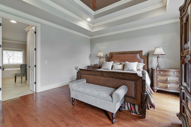 bedroom featuring a raised ceiling, wood-type flooring, and crown molding