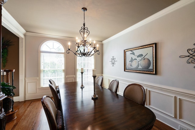 dining space with hardwood / wood-style flooring, a notable chandelier, and ornamental molding