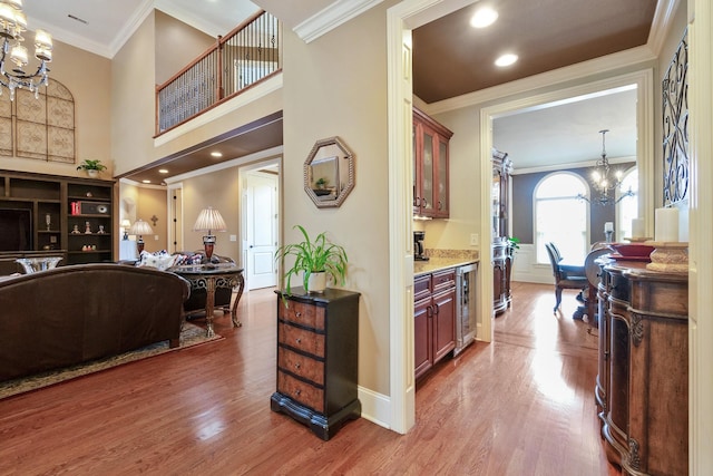 kitchen with hardwood / wood-style floors, decorative light fixtures, ornamental molding, and wine cooler