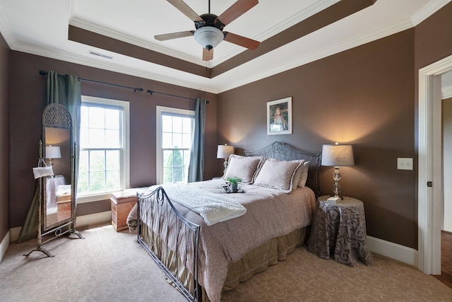 carpeted bedroom featuring a tray ceiling, ceiling fan, and crown molding