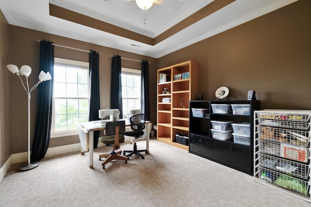 carpeted office featuring ceiling fan, a raised ceiling, and ornamental molding