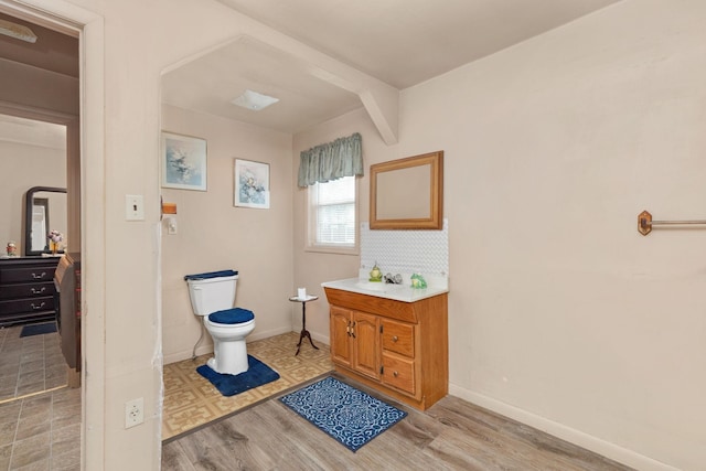 bathroom with hardwood / wood-style floors, vanity, and toilet