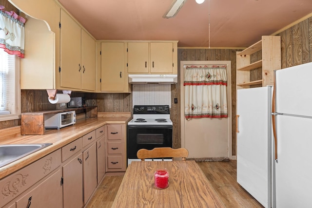 kitchen with cream cabinetry, white appliances, light hardwood / wood-style floors, and sink