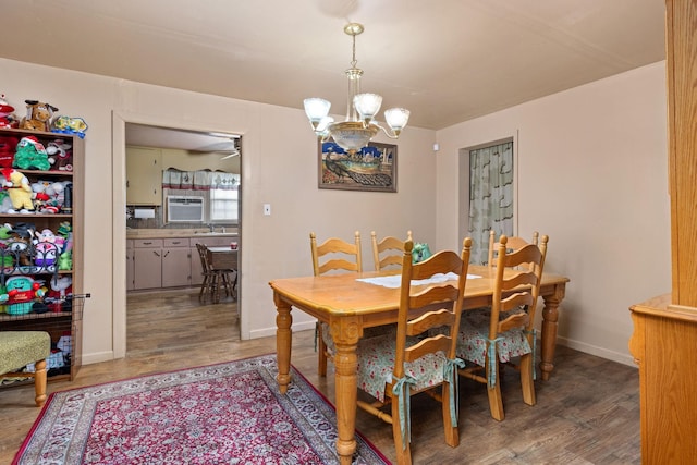 dining space with sink, hardwood / wood-style floors, and a notable chandelier