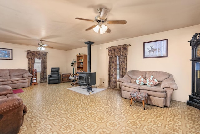 living room featuring a wood stove and ceiling fan