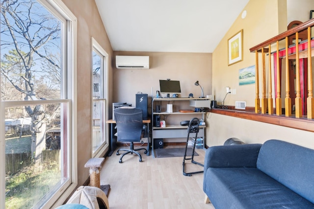 office area featuring light hardwood / wood-style floors, lofted ceiling, a healthy amount of sunlight, and an AC wall unit