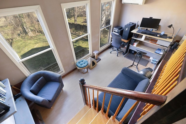 home office featuring a healthy amount of sunlight, light hardwood / wood-style floors, and a wall mounted AC