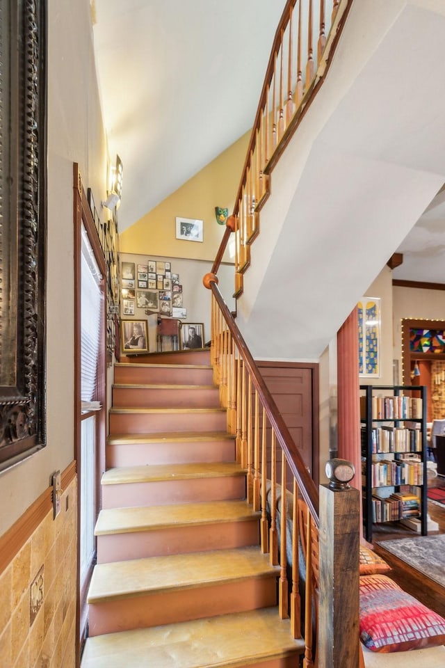 stairway with crown molding and plenty of natural light