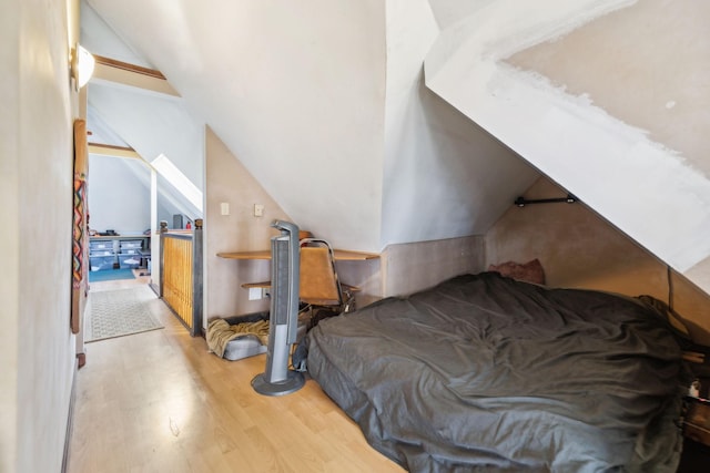 bedroom with vaulted ceiling and light wood-type flooring