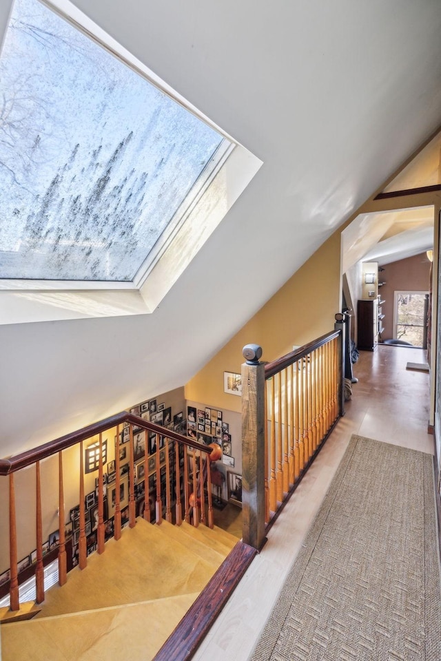 hall featuring lofted ceiling with skylight