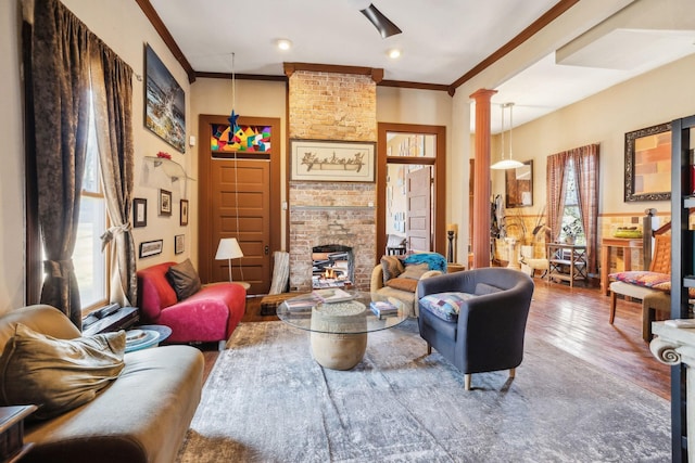 living room featuring hardwood / wood-style floors, ornate columns, and crown molding