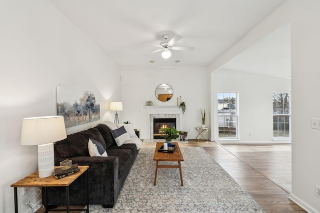 living room featuring a fireplace, hardwood / wood-style floors, lofted ceiling with beams, and ceiling fan