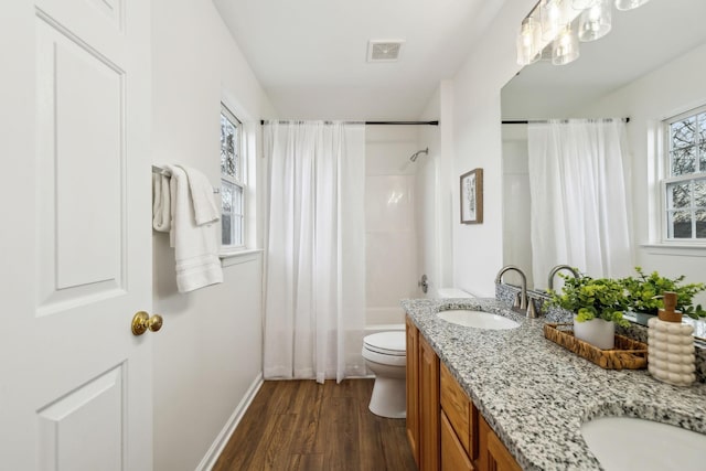 full bathroom with vanity, toilet, shower / bath combo with shower curtain, a healthy amount of sunlight, and wood-type flooring