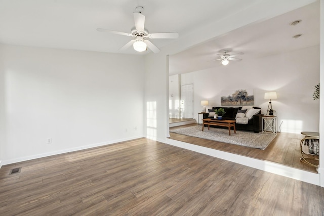 living room featuring ceiling fan, hardwood / wood-style floors, and beamed ceiling