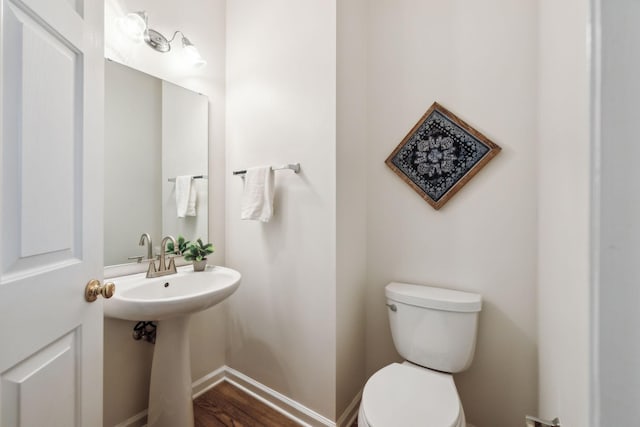 bathroom with hardwood / wood-style flooring, toilet, and sink