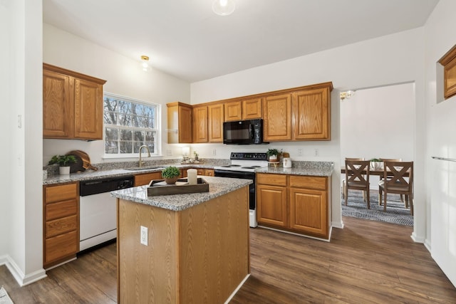 kitchen featuring dark hardwood / wood-style flooring, a center island, light stone counters, and white appliances