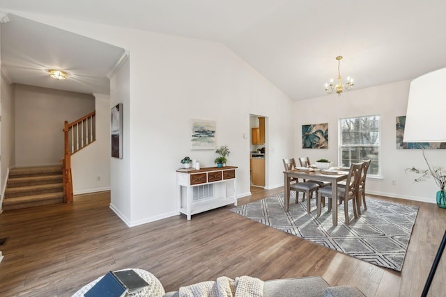 dining space featuring a notable chandelier, wood-type flooring, and lofted ceiling