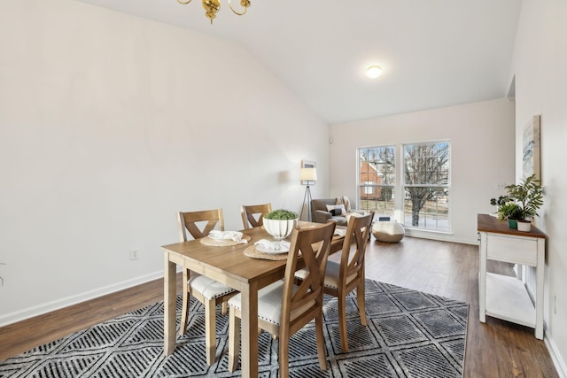 dining area featuring dark hardwood / wood-style floors, lofted ceiling, and a chandelier