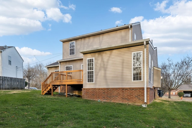 rear view of property with a lawn and a wooden deck