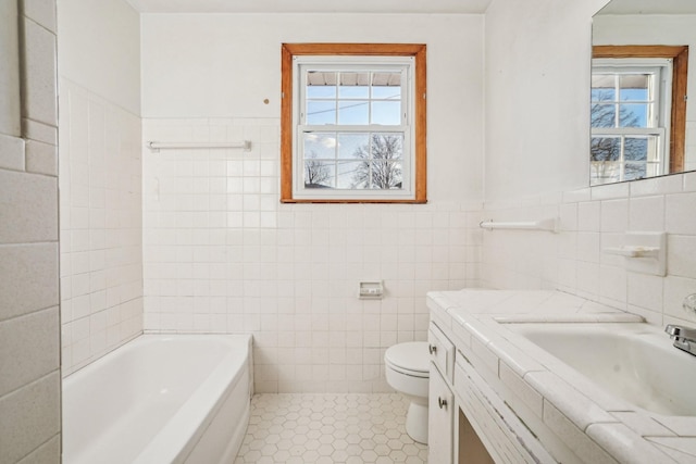 bathroom with tile patterned flooring, vanity, a bath, and tile walls