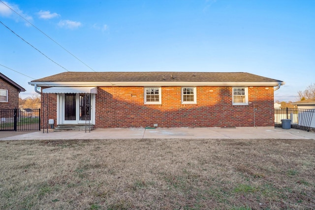 rear view of property featuring a patio and a lawn