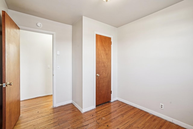 unfurnished bedroom featuring light hardwood / wood-style floors and a closet