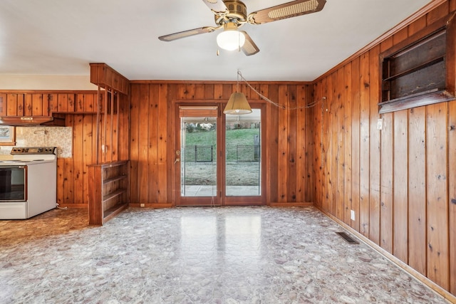 kitchen featuring electric range, ceiling fan, pendant lighting, and wooden walls