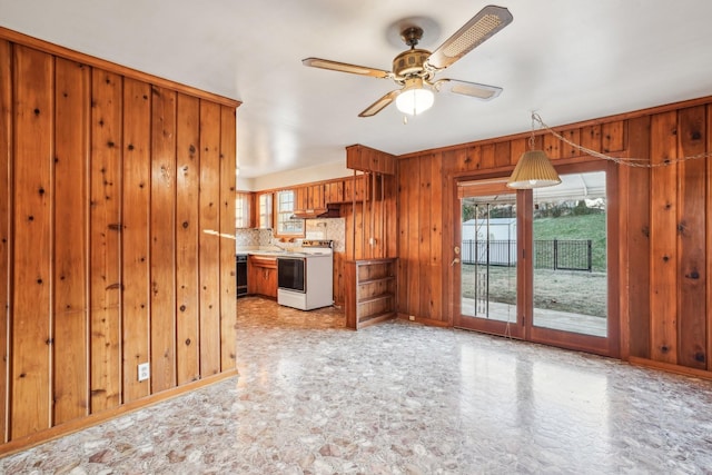 kitchen with white range with electric cooktop, ventilation hood, wooden walls, ceiling fan, and decorative backsplash