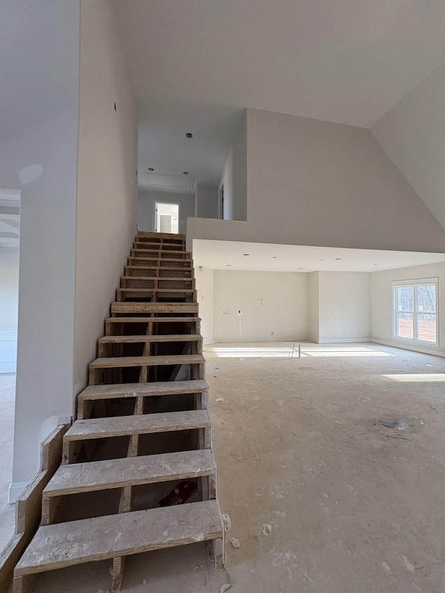 staircase with high vaulted ceiling