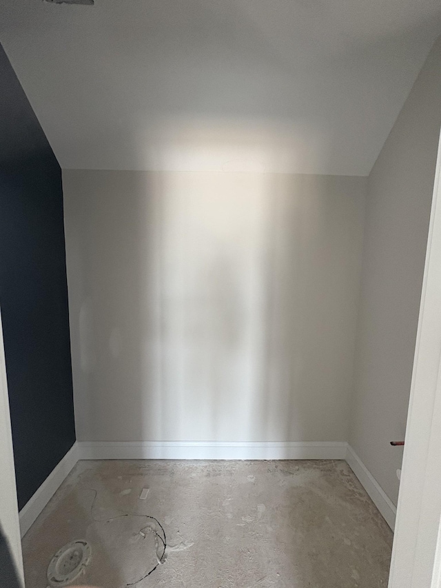 bonus room with baseboards and concrete floors