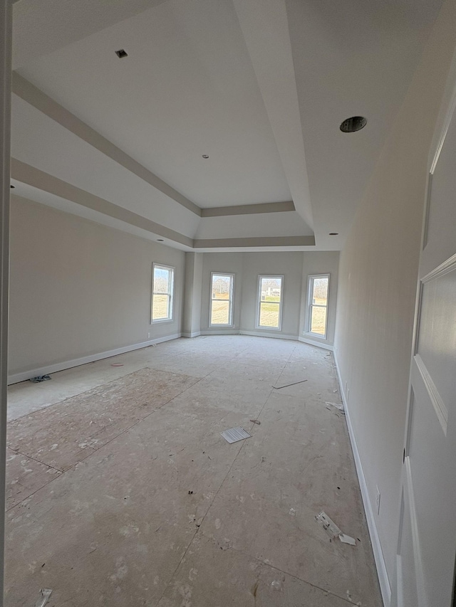 unfurnished room with a tray ceiling and baseboards