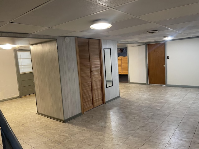 hall with a paneled ceiling and wooden walls