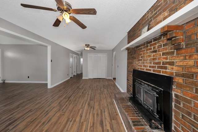 unfurnished living room featuring ceiling fan, dark hardwood / wood-style flooring, and a textured ceiling