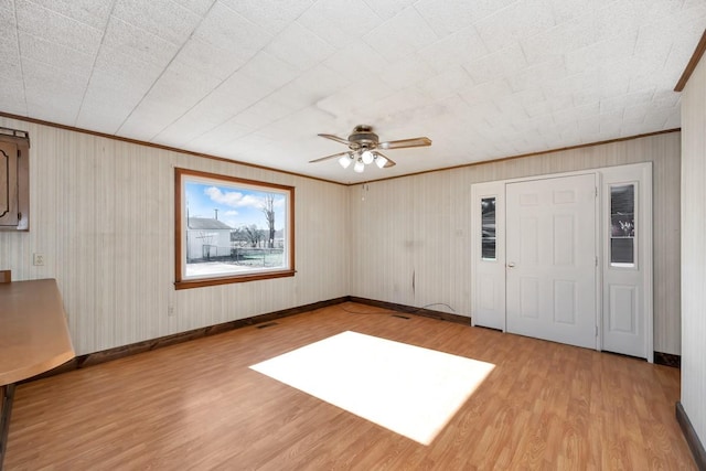 interior space with light hardwood / wood-style flooring, ceiling fan, and ornamental molding