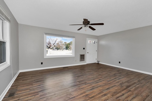 unfurnished living room featuring heating unit, ceiling fan, and dark hardwood / wood-style floors