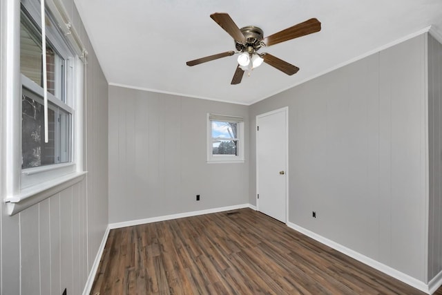 empty room with crown molding, ceiling fan, and dark hardwood / wood-style floors