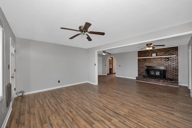 unfurnished living room with dark hardwood / wood-style floors, ceiling fan, and a textured ceiling