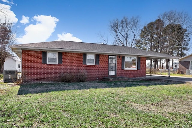 ranch-style house featuring a front yard, a carport, and cooling unit