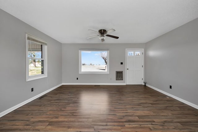 interior space with ceiling fan, dark hardwood / wood-style flooring, and heating unit