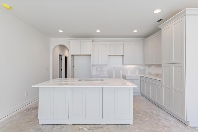 kitchen featuring a kitchen island with sink and white cabinets