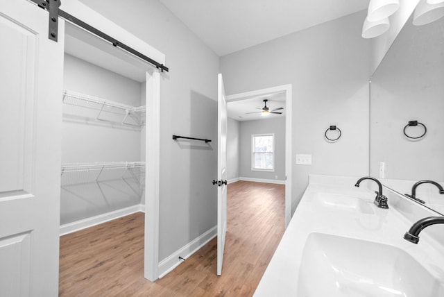 bathroom with wood-type flooring, vanity, and ceiling fan