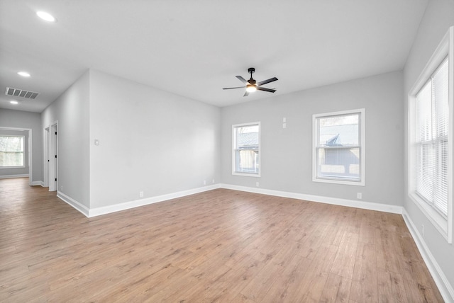 empty room with ceiling fan and light hardwood / wood-style flooring