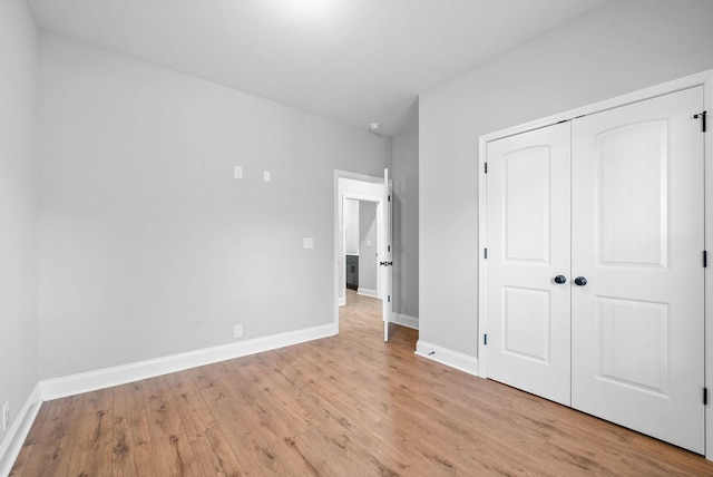 unfurnished bedroom featuring light wood-type flooring and a closet