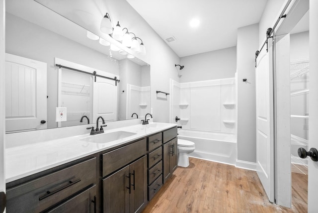 full bathroom featuring vanity, wood-type flooring, bathtub / shower combination, and toilet