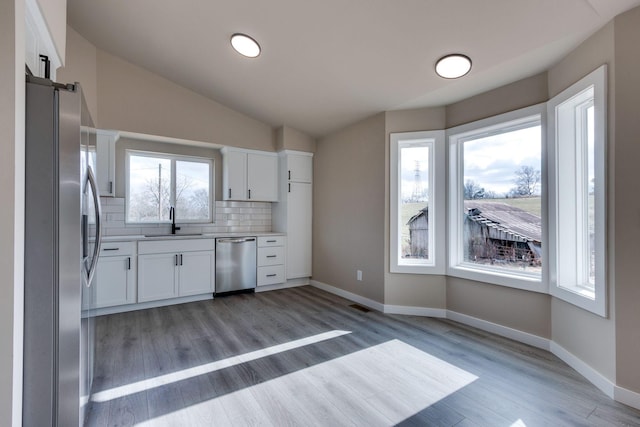 kitchen with white cabinets, sink, backsplash, and appliances with stainless steel finishes