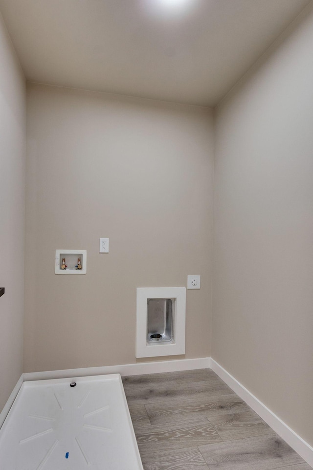 clothes washing area featuring washer hookup and light hardwood / wood-style floors