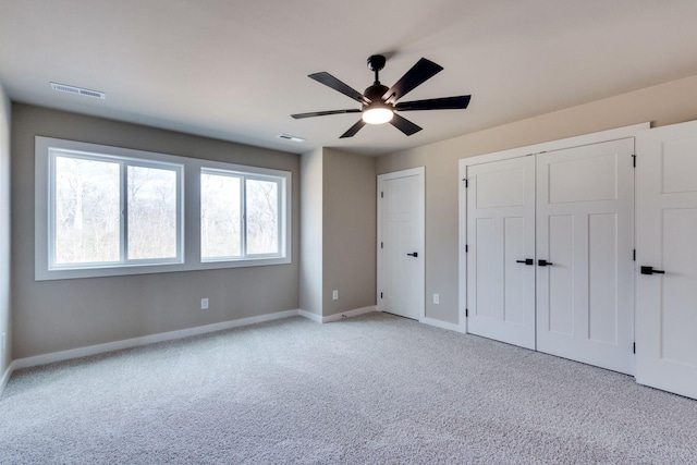 unfurnished bedroom with light colored carpet and ceiling fan