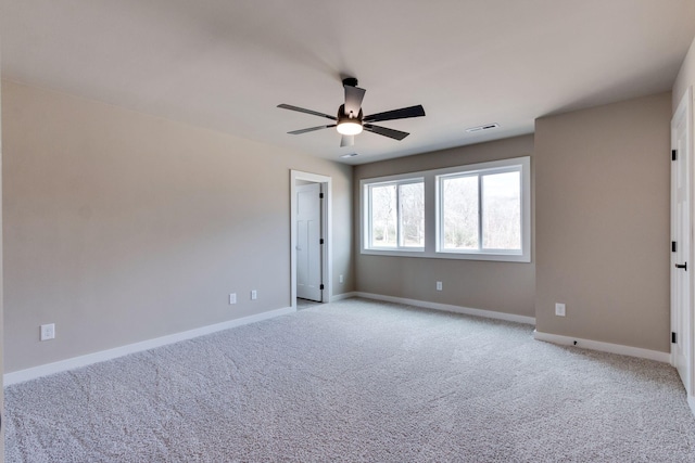 spare room featuring light colored carpet and ceiling fan