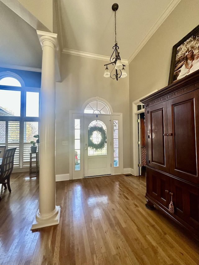 entryway with wood-type flooring, a wealth of natural light, and decorative columns