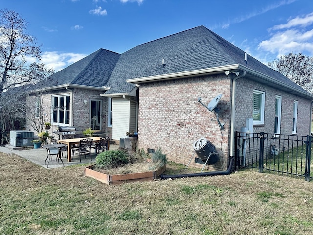 back of house featuring central AC, a patio area, and a lawn